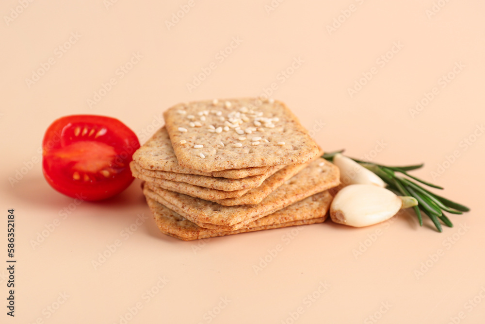 Stack of tasty crackers with sesame, garlic, tomato and rosemary on beige background Stack of tasty crackers with sesame, garlic, tomato and rosemary on beige background
