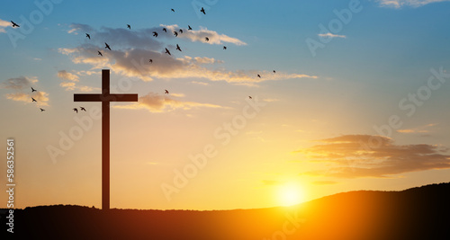 Christian cross on hill outdoors at sunrise. Resurrection of Jesus. Concept photo.