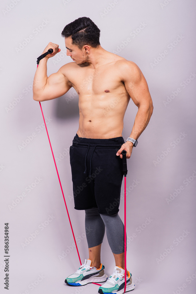 Athletic man skipping with a jump rope on grey background. Best cardio workout Athletic man skipping with a jump rope on grey background. Best cardio workout