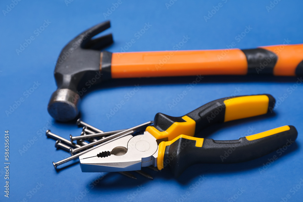 Pliers, hammer and nails on blue background Pliers, hammer and nails on blue background