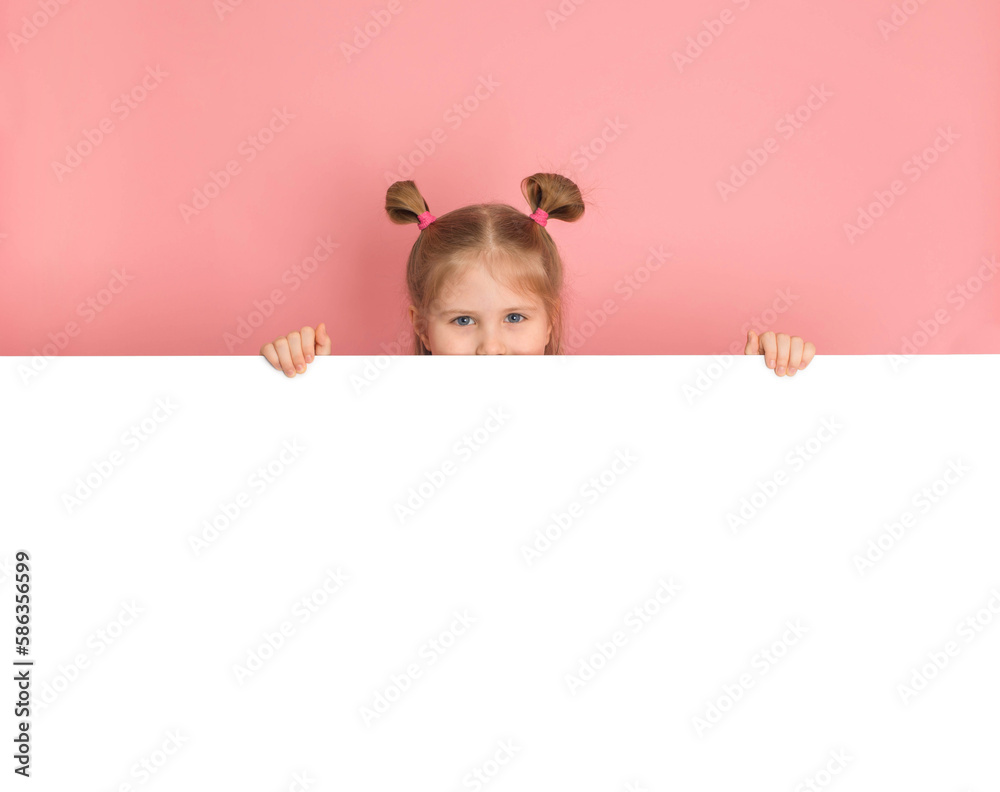 Funny girl hiding behind blank white advertising billboard with copy space and peeking out pink wall. Funny girl hiding behind blank white advertising billboard with copy space and peeking out pink wall.