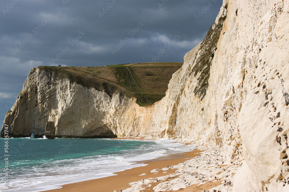 Gloomy view on limestone cliffs with roaring waves - Jurassic Coast, Dorset, England. Landscape photography.