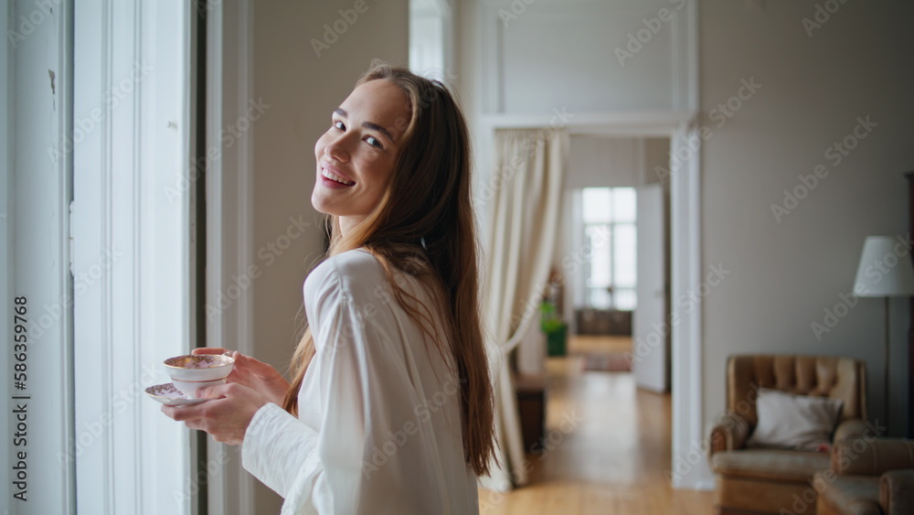 Smiling model touching hair at morning room portrait. Happy lady looking camera Smiling model touching hair at morning room portrait. Happy lady looking camera
