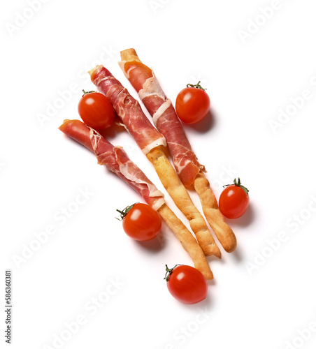 Tasty Italian Grissini with bacon and tomatoes on white background