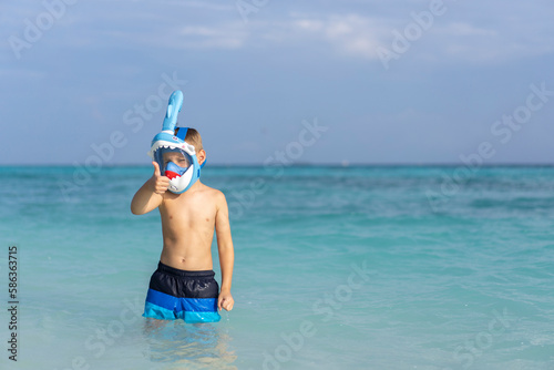 A little boy in a full face mask is snorkeling in the Maldives © Marina