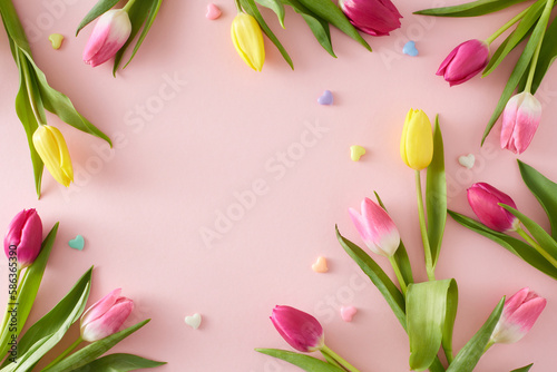 Fototapeta Naklejka Na Ścianę i Meble -  Mother's Day atmosphere concept. Creative layout made of colorful tulips flowers and hearts baubles on isolated pastel pink background. Flat lay copyspace