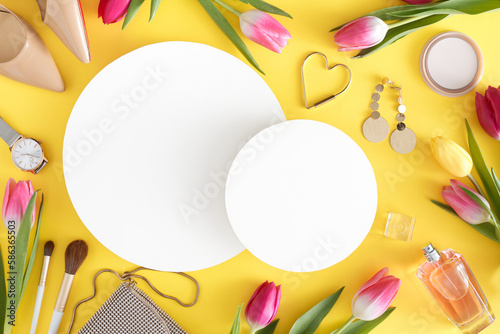 Top view photo of white circles trendy women shoes perfume bottle cosmetics bijouterie handbag modern watches and colorful tulips on light yellow background with blank space. Women's Day concept.