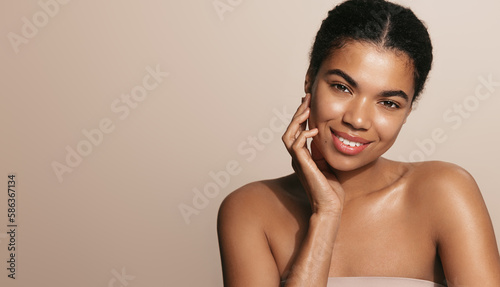 Beauty and health. Young african american woman with healthy, natural skin, beautiful face without blemishes, touches her soft chick after cleansing gel, takes off her makeup