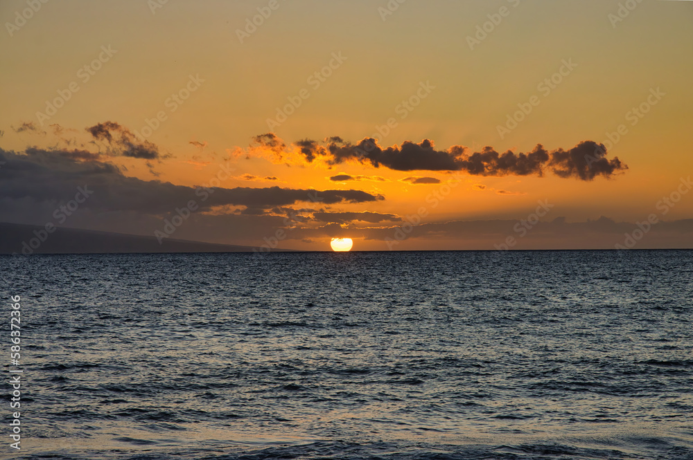 Golden sunset over a calm Maui ocean.