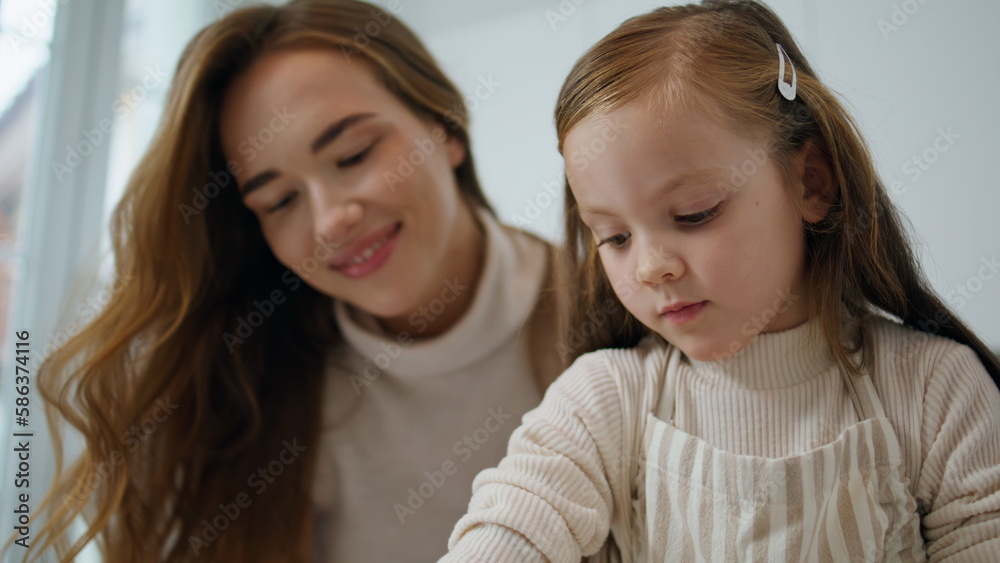 Loving mother kissing child kitchen portrait. Smiling woman embracing daughter Loving mother kissing child kitchen portrait. Smiling woman embracing daughter