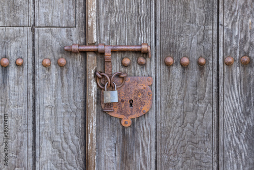 Rusted lock on a wooden door.