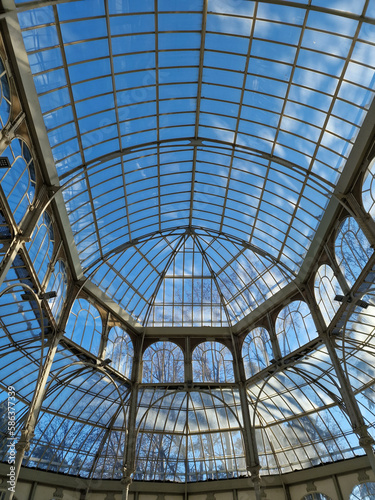 An interesting combination of glass and metal in Palacio de Cristal located in the de El Retiro park in Madrid on a sunny day, Madrid, Spain.