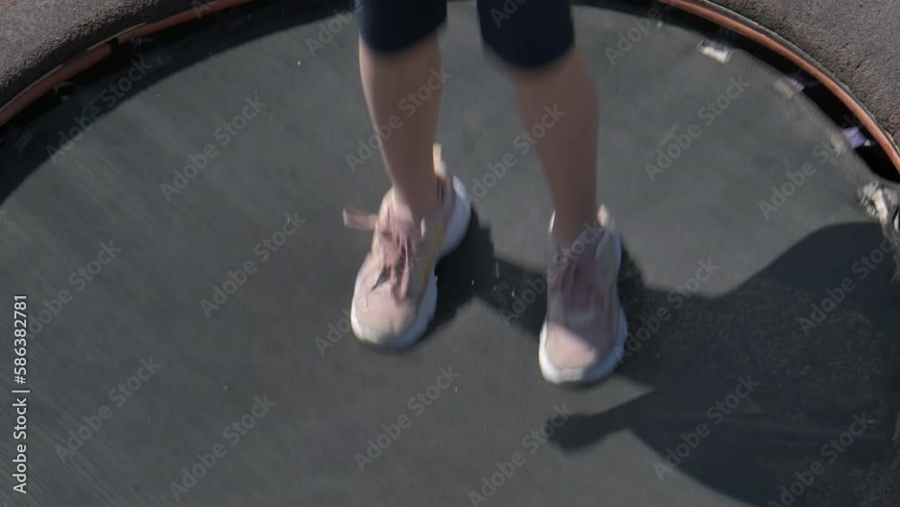 One pair of legs on trampoline. A view of child legs jumping on small