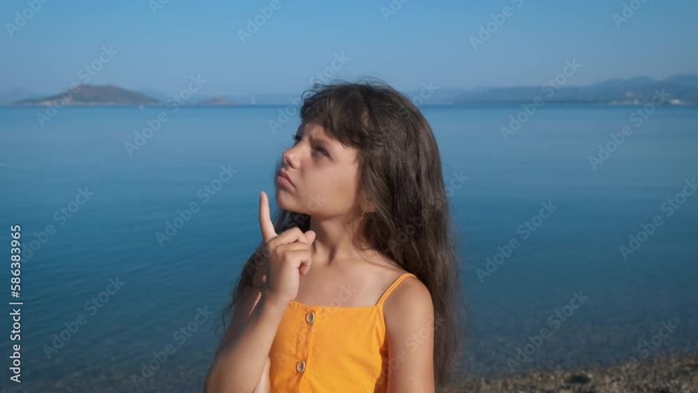 Child vacation against morning sea. A thoughtful girl pass her time on the shore during summer time. Child vacation against morning sea. A thoughtful girl pass her time on the shore during summer time.