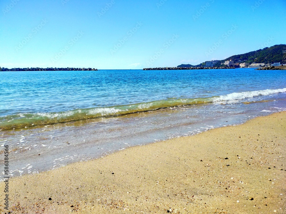 日本の和歌山県の観光地、快水浴百選海の部特選にも選ばれた片男波海水浴場の砂浜の波打ち際の夏の風景（コピースペースあり）