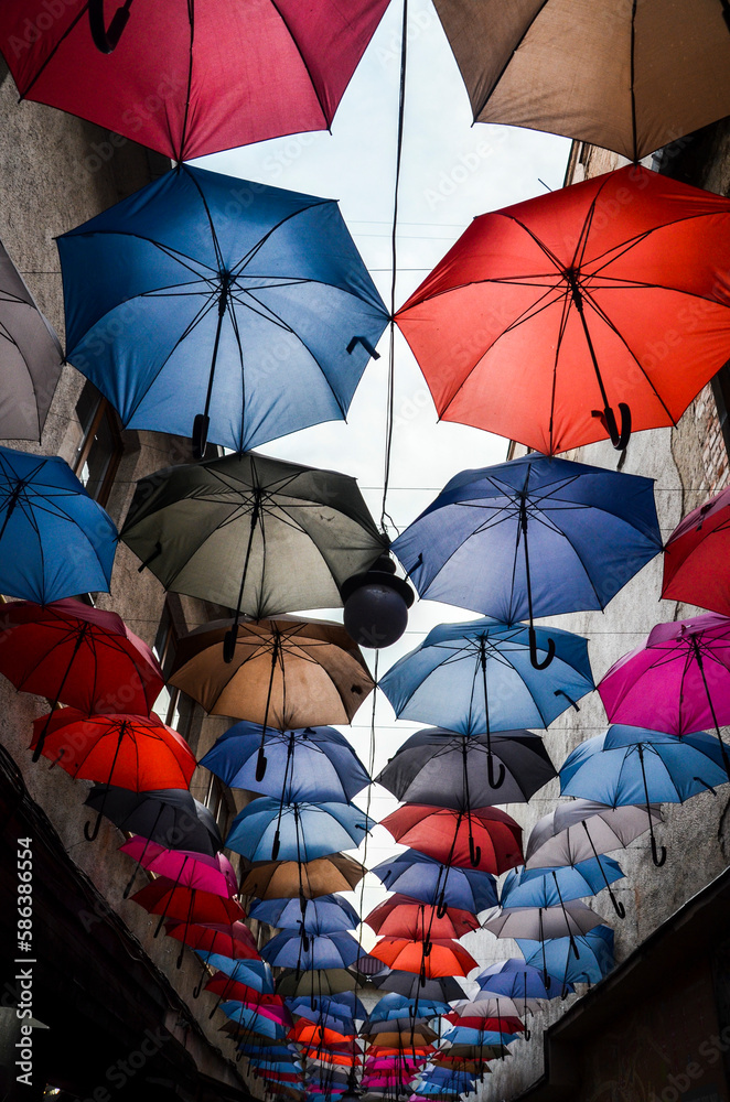 Bright and colorful hanging umbrellas over the street against the sky. multicolor street decoration