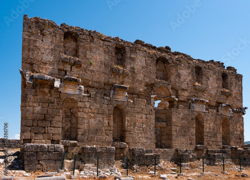 View of partially reconstructed facade of Nymphaeum building at archaeological site of ancient city of Aspendos on sunny day, Turkey..