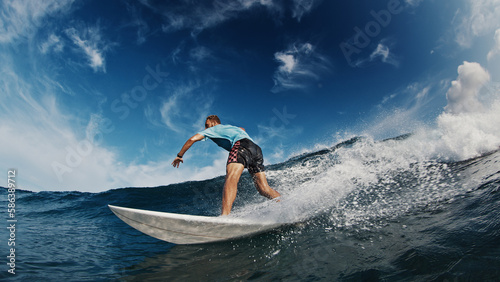 Surfer rides the wave. Young man aggressively surfs the ocean wave in the Maldives with lots of splashes