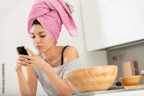 Freshly washed hair, girl on smartphone, bright kitchen, multita photo