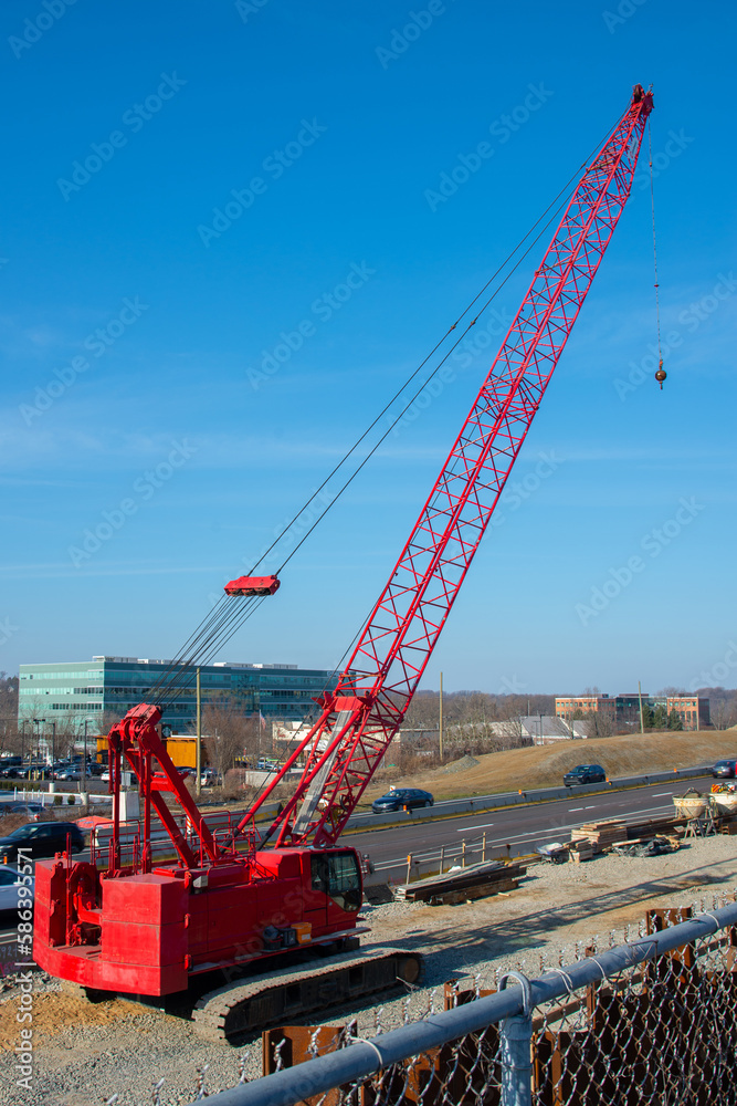 red truck crane boom with hooks and scale weight above blue sky