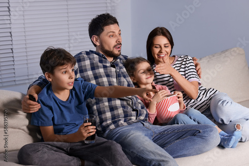 Family watching TV at home in evening