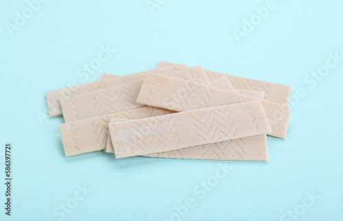 Many sticks of tasty chewing gum on light blue background