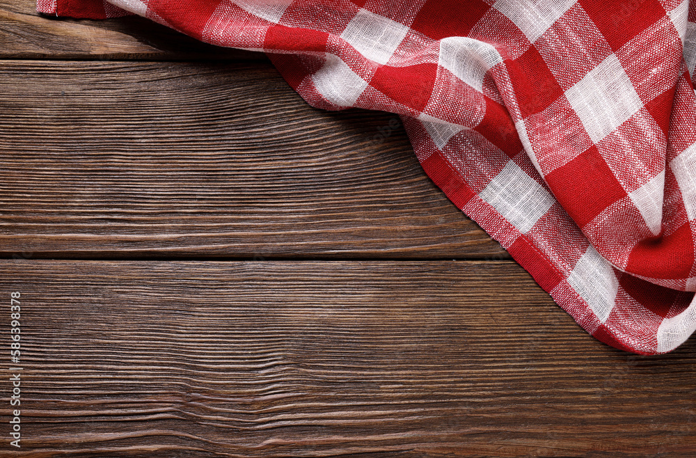 Red checkered tablecloth on wooden table, top view. Space for text Red checkered tablecloth on wooden table, top view. Space for text