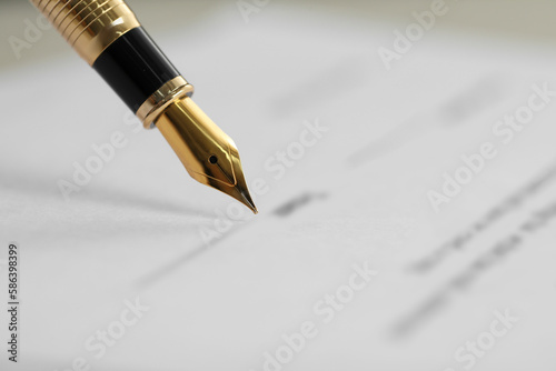 Signing document with fountain pen, closeup. Notary services
