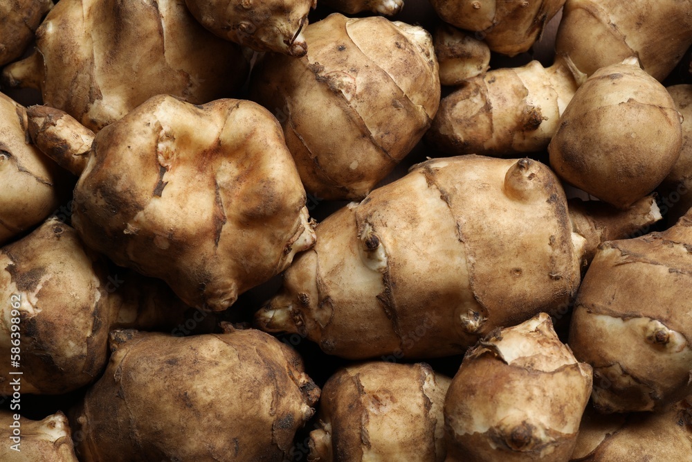 Many fresh Jerusalem artichokes as background, top view Many fresh Jerusalem artichokes as background, top view
