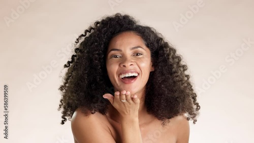 Skincare, face and woman blowing a kiss in the studio with a natural, beauty and self care routine. Cosmetic, happy and portrait of female model from Mexico with intimate gesture by brown background. photo