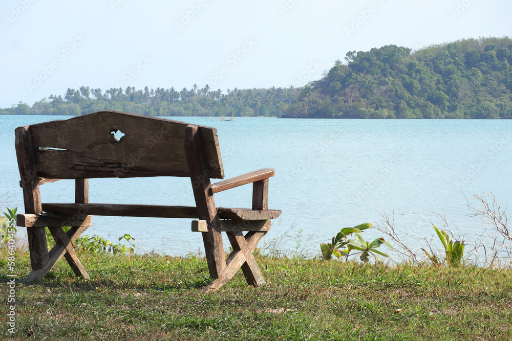 Beautiful scenery and empty wooden bench with beautiful beach in background. Scenic relaxing scenery
