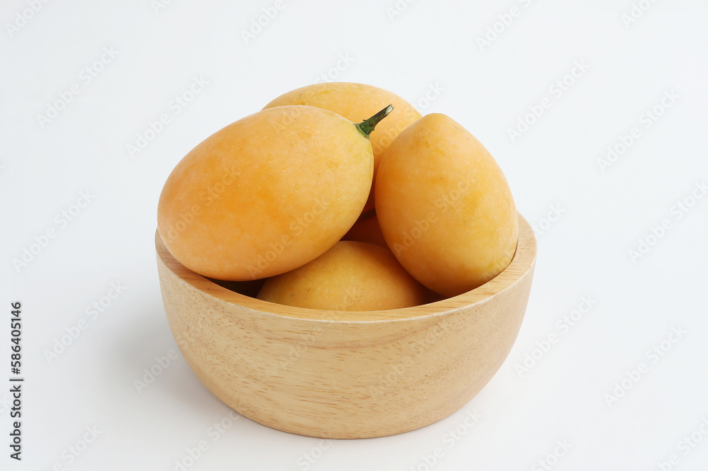 Fresh Marian Plum, (Bouea macrophylla Griffith), Ripe plum mango in wooden bowl on white background. Fresh Marian Plum, (Bouea macrophylla Griffith), Ripe plum mango in wooden bowl on white background.