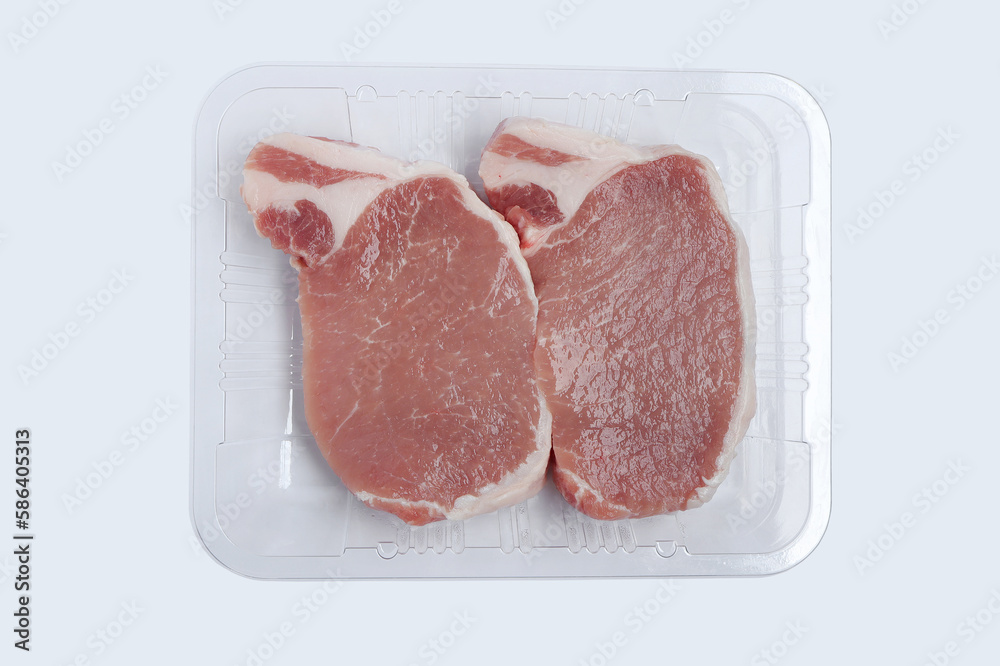 Sliced raw pork meat in plastic tray on white background. Top view with clipping path.