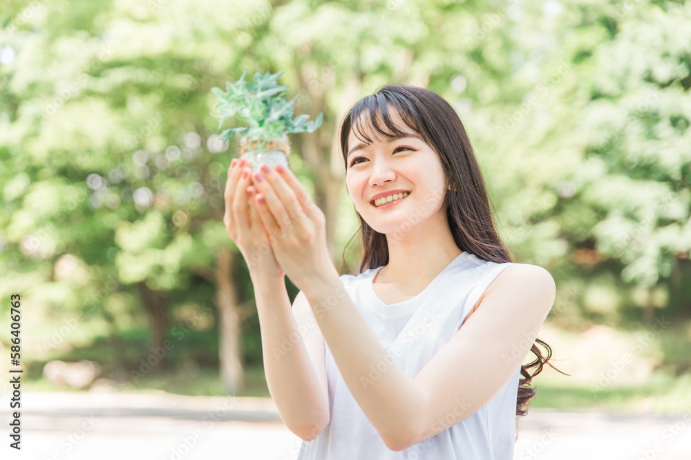植物を持つ笑顔の日本人女性
