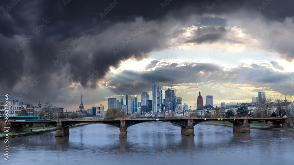 Panorama shot of cloudburst and sun rays shining on Frankfurt Skyline and Banking District