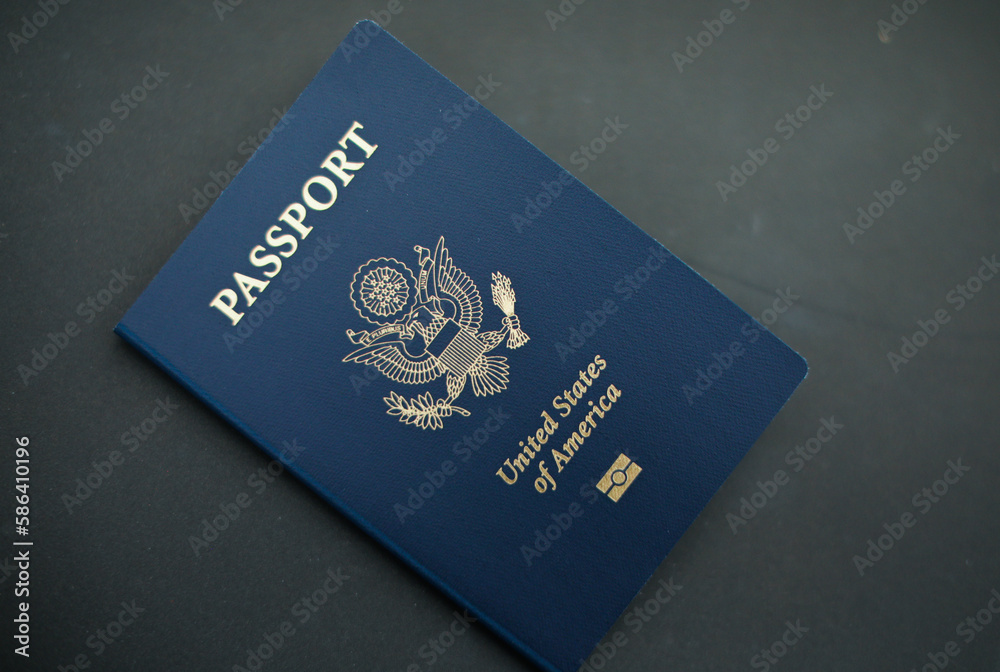 Close-up of a US passport with immigration, visa, citizenship, and travel paperwork on a wooden table Close-up of a US passport with immigration, visa, citizenship, and travel paperwork on a wooden table