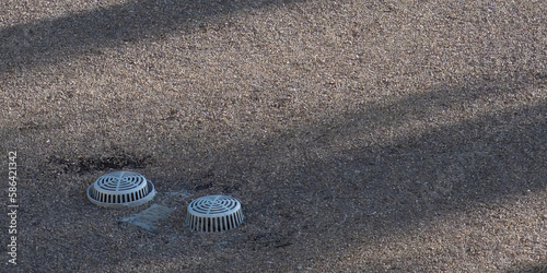 Flat building roof top with ventilation and covered stormwater intake visible. 