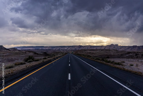 Road to the horizon between mountains and deserts. Beautiful view of way to infinity. Us road and highway extends the west