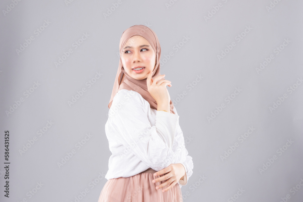 Young smiling confident asian muslim woman in hijab over isolated over background studio. Casual hijab fashion. Young smiling confident asian muslim woman in hijab over isolated over background studio. Casual hijab fashion.