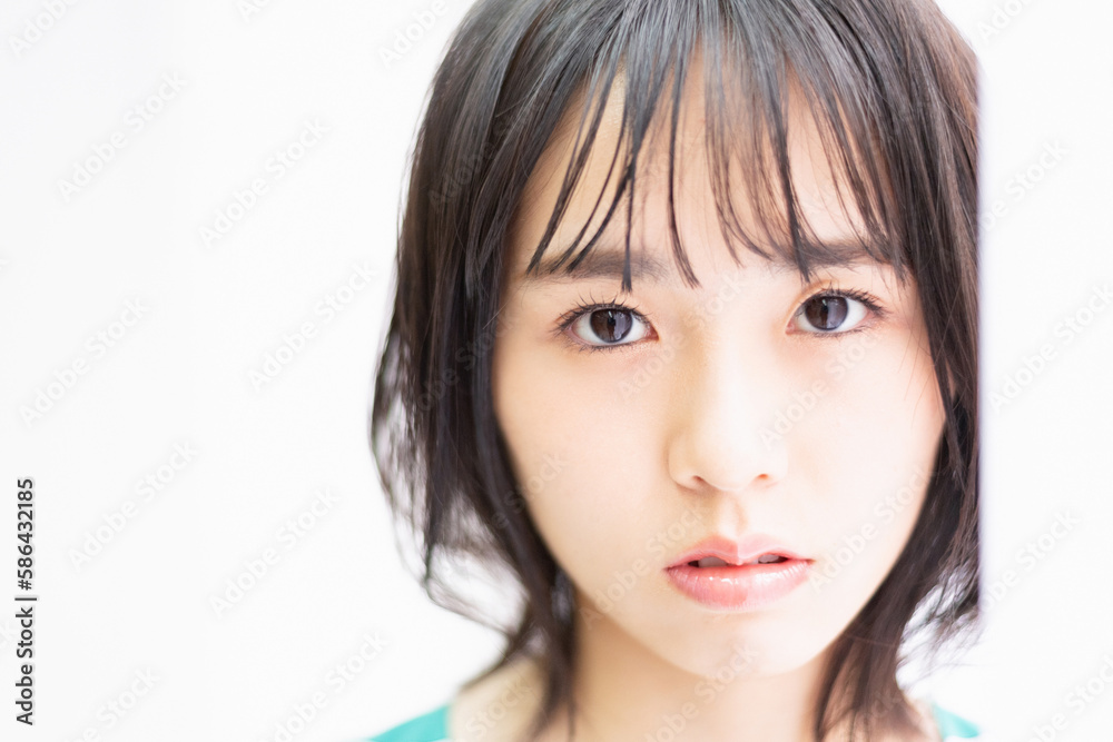 窓際に立ってこちらを見つめている若い女性 窓際に立ってこちらを見つめている若い女性