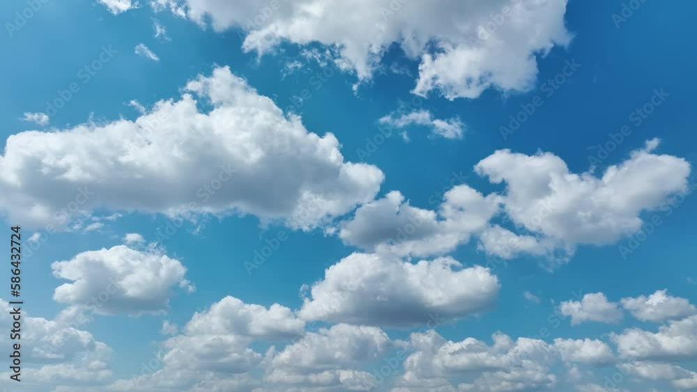 White puffy cumulus clouds on summer blue sky. Panning shot of cloudscape weather White puffy cumulus clouds on summer blue sky. Panning shot of cloudscape weather