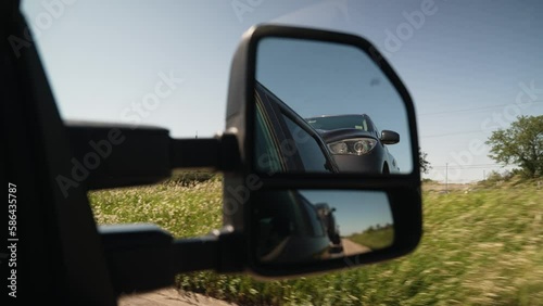 interesting view of a car hauled by a wedge car trailers-carhauling. With small reflection in the window. Trailer is pulled by a pickup truck. Similar view as tow truck photo