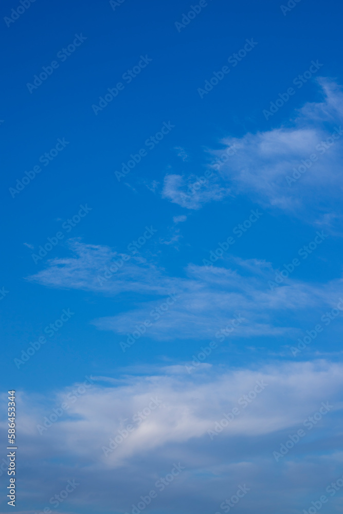Blue sky background and white clouds soft focus and copy space. Vertical shot