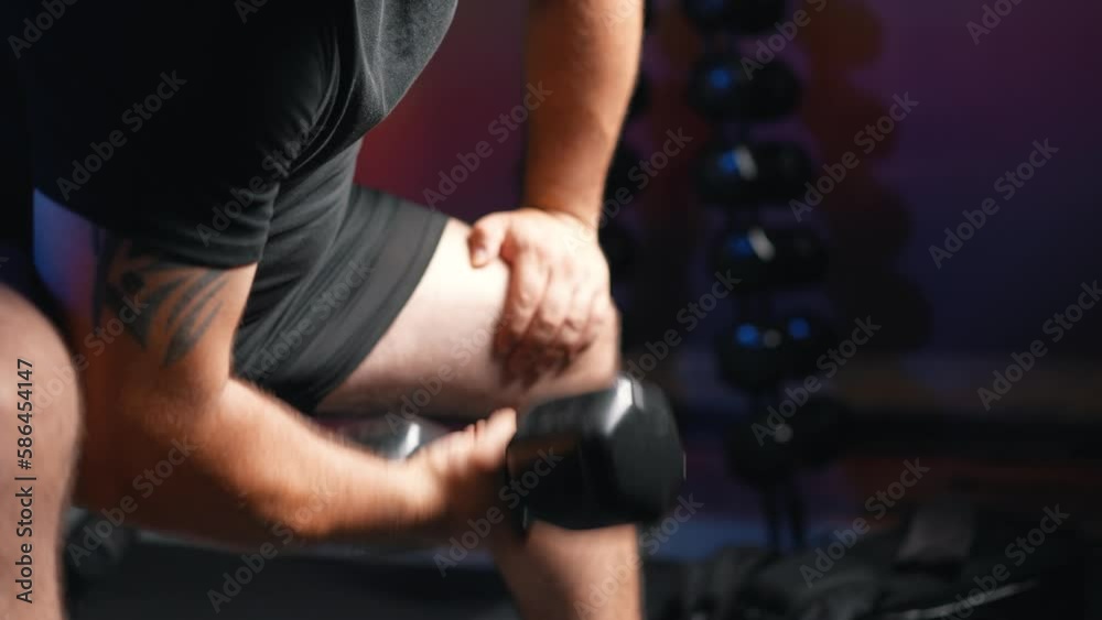 Man biceps training with dumbbell weight in dark gym Man biceps training with dumbbell weight in dark gym