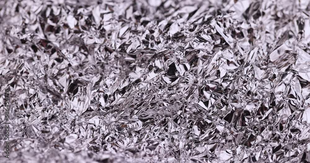 move old used crumpled aluminum foil, close-up of a foil structure with crumbs from food