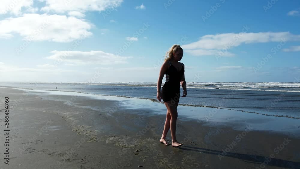 Sexy woman in black dress walking and enjoying at the seaside. Drone flight. Slow motion. Sexy woman in black dress walking and enjoying at the seaside. Drone flight. Slow motion.