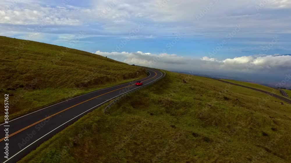 Cars driving along scenic pastures on Hawaii's Big Island - aerial follow Cars driving along scenic pastures on Hawaii's Big Island - aerial follow