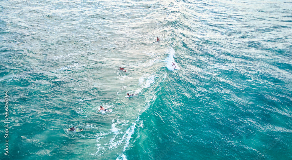 Aerial view of surfers in the ocean waiting for the waves
