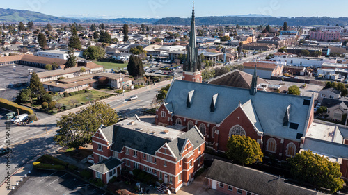 Watsonville, California, USA - January 1, 2023: Sun shines on a historic church and surrounding city of downtown Watsonville. photo