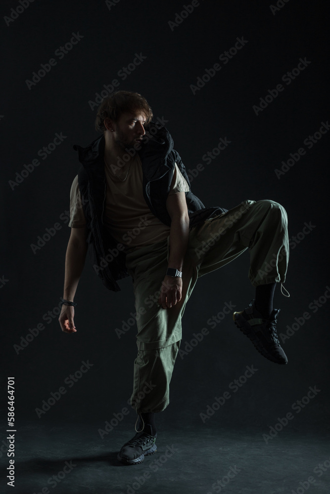 Stylish trendy dancer man in fashion clothes is dancing in the dark. Guy dancer silhouette Stylish trendy dancer man in fashion clothes is dancing in the dark. Guy dancer silhouette